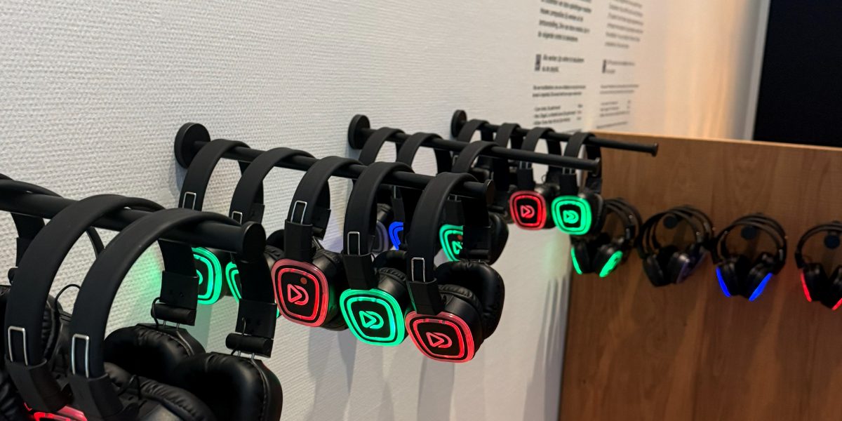 Headphones on a wall rack at the entrance to an exhibition