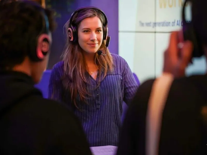 Workshop med en taler med headsetmikrofon, gruppen lytter med hovedtelefoner