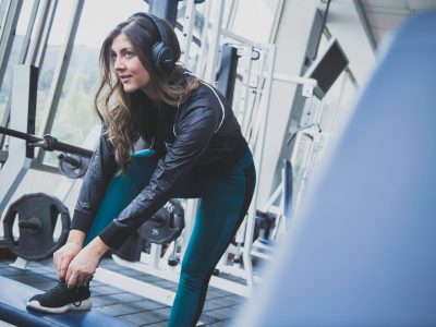 Vrouw in de sportschool - koptelefoon tijdens het sporten - Dolly Digital