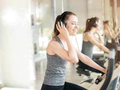 Vrouw in de sportschool met koptelefoon tijdens het sporten - Dolly Digital