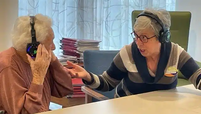 Due anziani cantano insieme con le cuffie - attività musicali per anziani - Dolly Digital